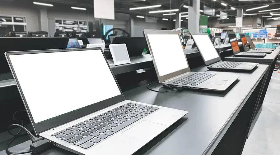 Refurbished Apple and Windows laptops displayed at PayMore Alafaya